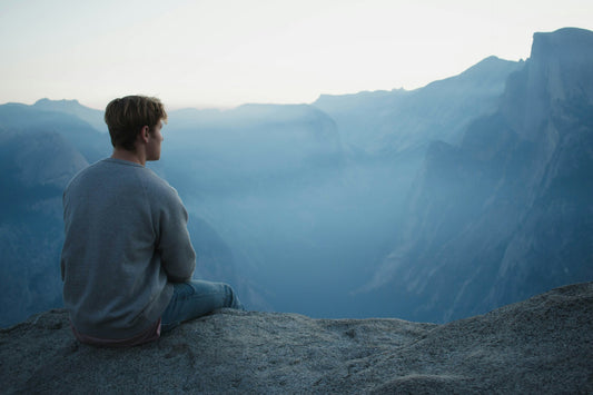 Man meditating on top of a mountain